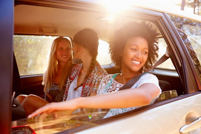 Three Friends In The Back Of A Vehicle On A Road Trip