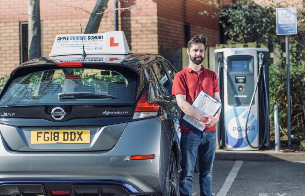 Learner Driver Standing Outside Of Instructor Vehicle