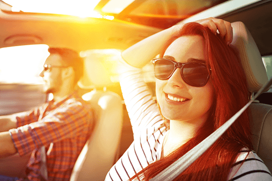 Young male and female in car with sun shining through window