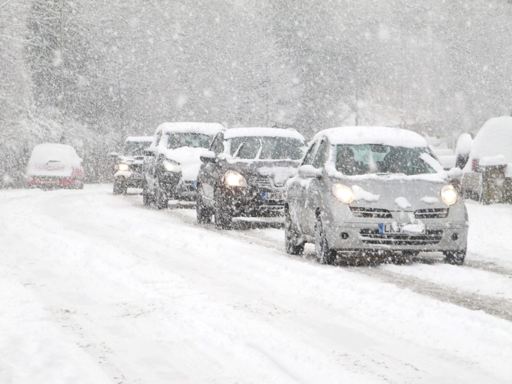 Cars driving in heavy snow.