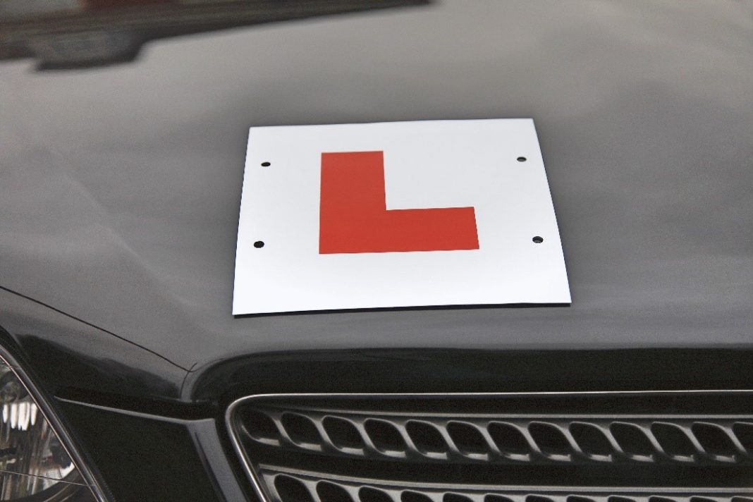 Learner driver L plate on black car