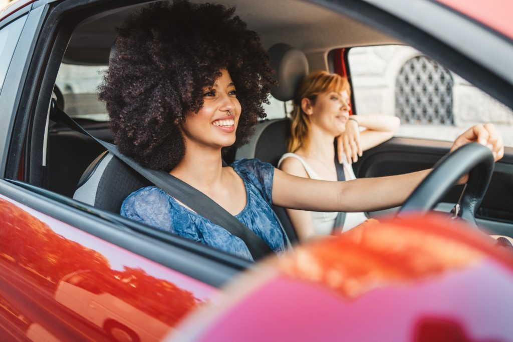 Two young women learning to drive in car