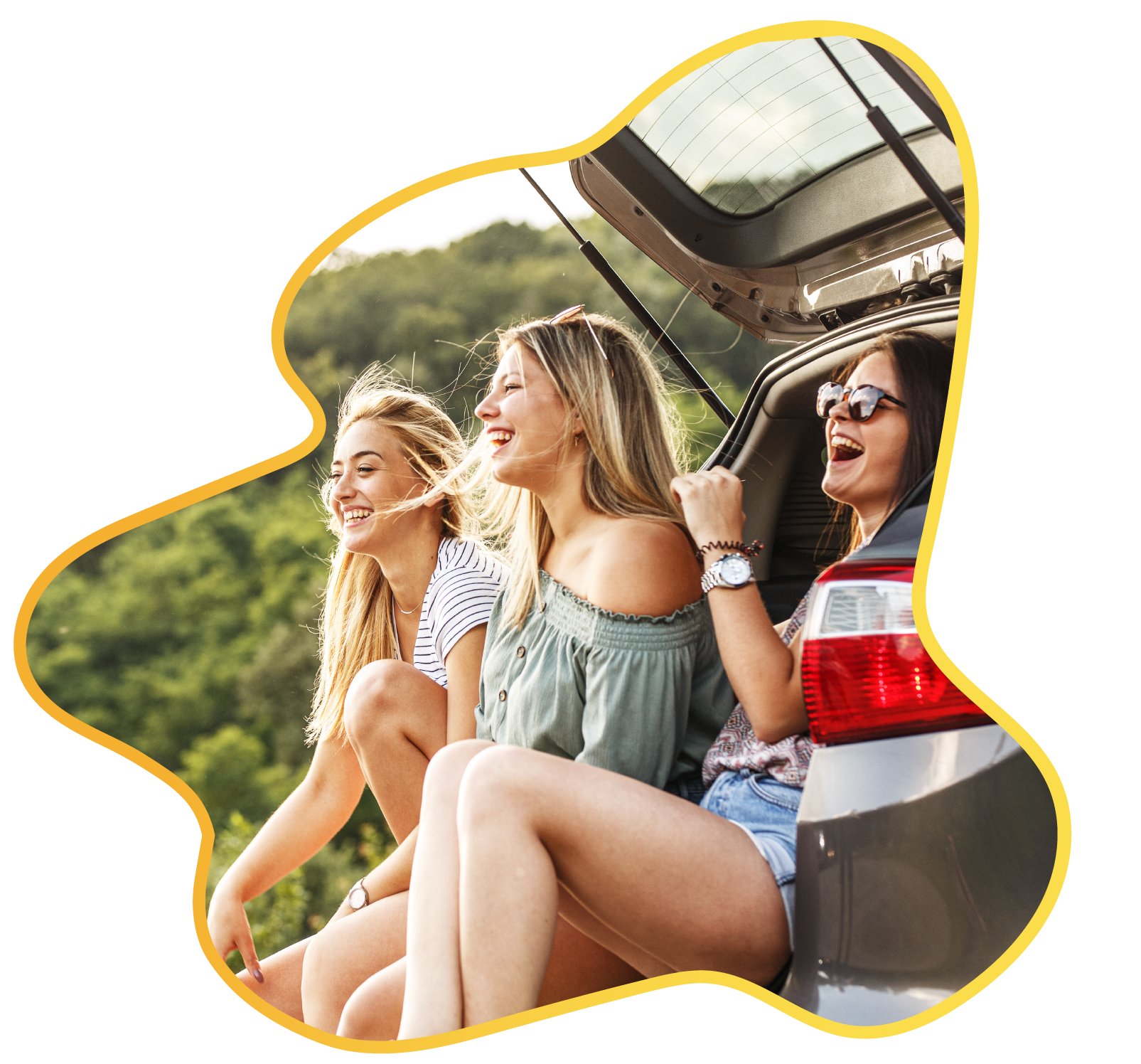 Three girls in boot of car laughing