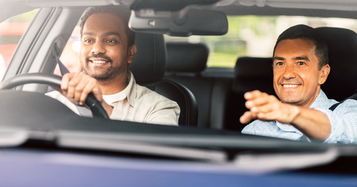 two males in front seats of car