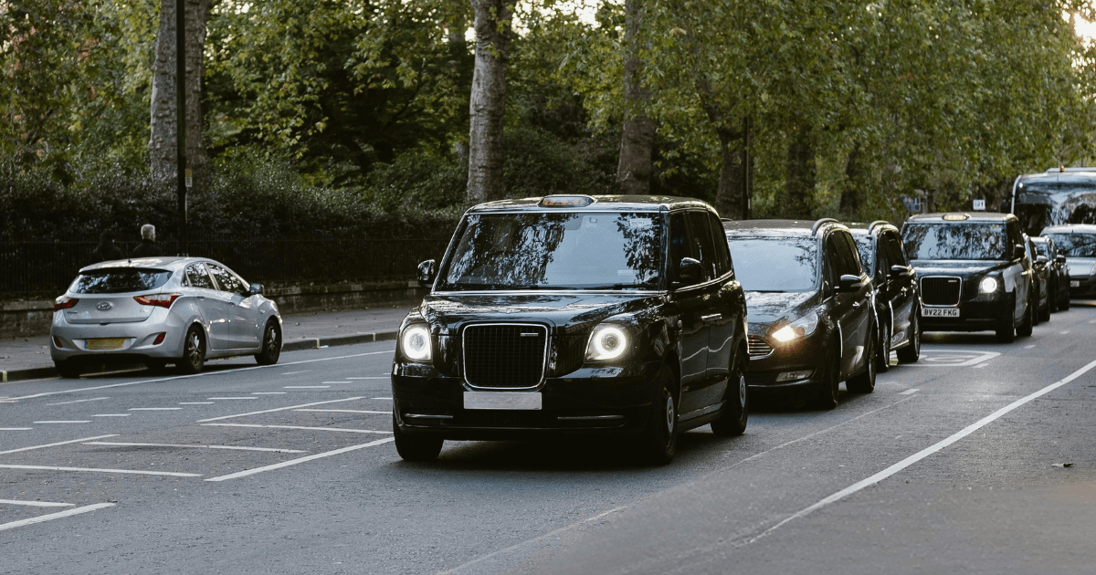 black taxi cab driving in a queue of traffic