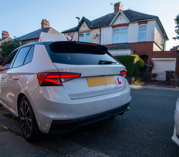 driving instructor's car with L plates on the top and back of the vehicle